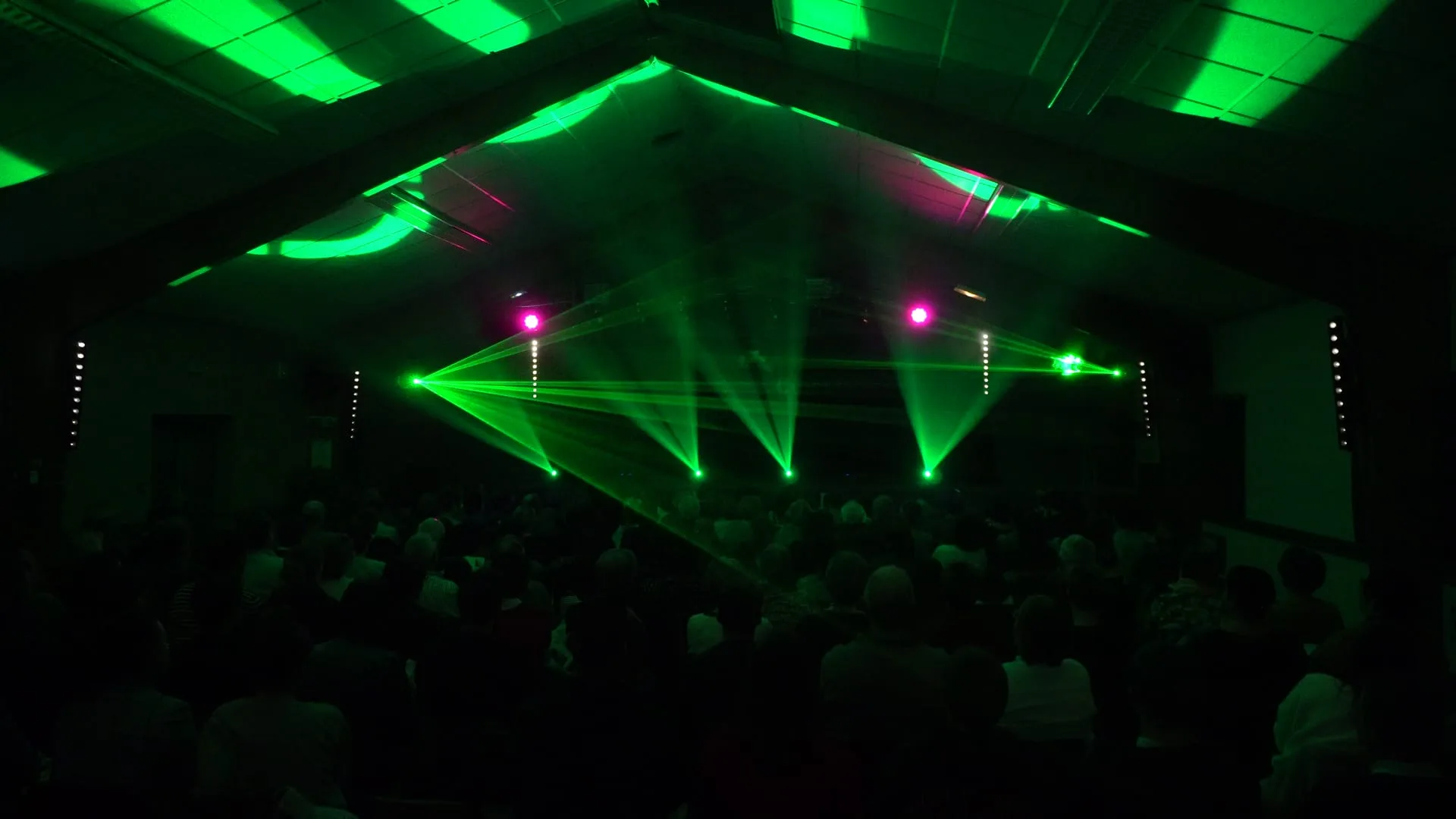 Éclairage laser vert et rose pendant le spectacle